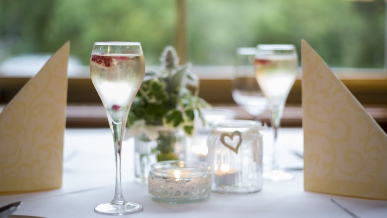 Alpen-Aktiv-Landgasthof zur Schubertlinde, © Patrick Haberler Elegante Tischdekoration mit Sektgläsern, Kerzen und Servietten.