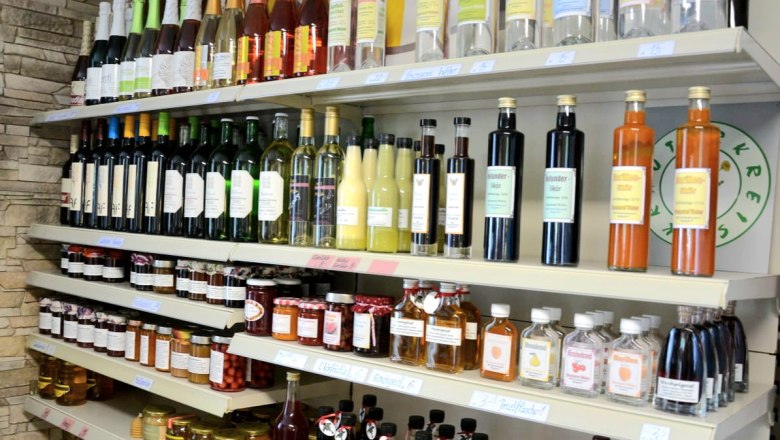 Vinegar, liqueurs & co, © Gemeinde Schwarzenbach Shelves with bottles and jars in a store.