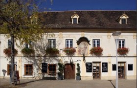 S Platzl außen, © Schilowsky_NM_©redtenbacher Historisches Gebäude mit Blumenkästen und Wandgemälde.