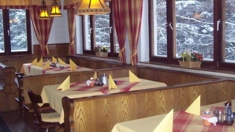 Luf Inn, © Gasthaus Luf Interior view of a cozy inn with wooden furniture and laid tables.