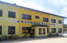Gasthaus Kabinger in Bromberg, © Wiener Alpen Gelbes Gebäude mit der Aufschrift 'Gasthaus Kabinger'.