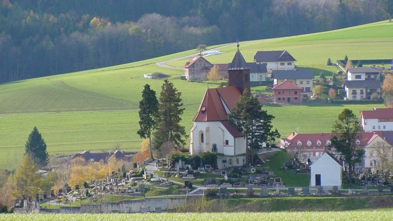 Erasmuskirche in Krumbach, © Steindy, CC BY-SA 3.0 Erasmuskirche in Krumbach mit umliegendem Friedhof und grüner Landschaft.