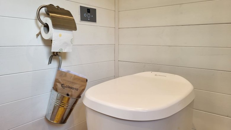 Wasserloses Clesana-WC mit Beutelverschweißung, © Villa to go Wasserloses Clesana-WC mit Beutelverschweißung in einem Raum mit Holzverkleidung.