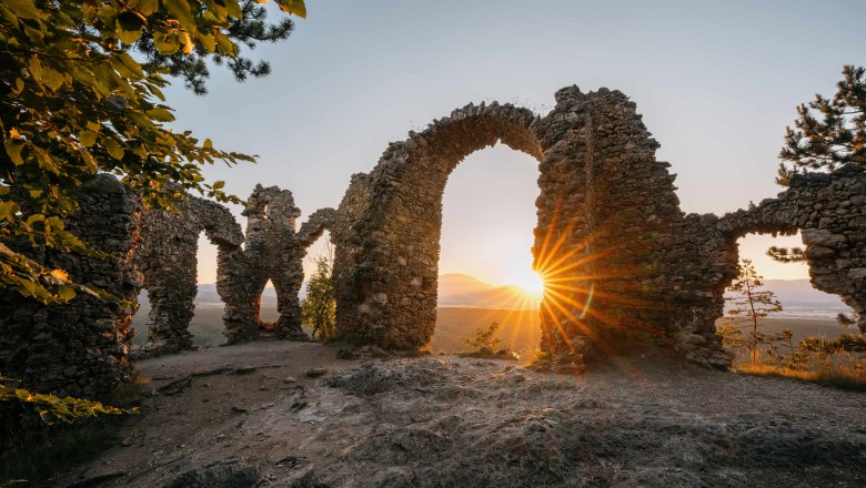 Ruine Türkensturz, © Wiener Alpen, Roman Königshofer Ruine Türkensturz bei Sonnenuntergang mit Sonnenstrahlen durch die steinernen Bögen.
