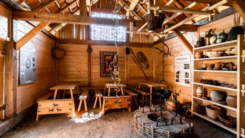 Celtic village Schwarzenbach, © Wiener Alpen, Christian Kremsl Interior view of a reconstructed Celtic house with wooden furniture and pottery.