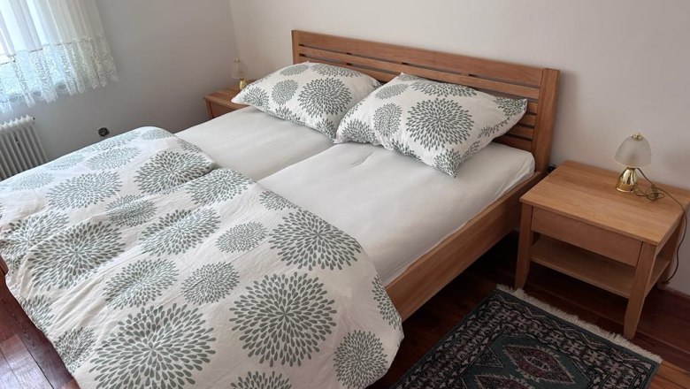 Schlafzimmer, © Kainz-Waldinger Schlafzimmer mit Doppelbett, Holzmöbeln und Teppich.