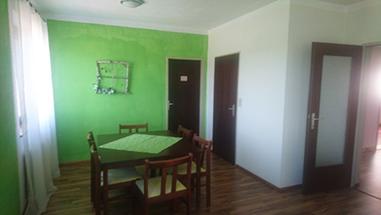 Dining area, © Anke Spreitzer Dining area with green-painted wall, wooden table and chairs.