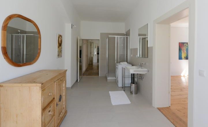 Apartment G1 im Gerhardthof Reichenau, © Gerhardthof Reichenau Innenansicht eines modernen Badezimmers mit Holzmöbeln und Dusche.