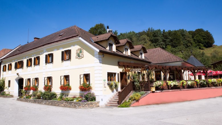 Hausansicht, © Gasthaus Buchegger, Foto Buchergger Traditionelles Gasthaus gelber Fassade, vielen Fenstern und Terasse.