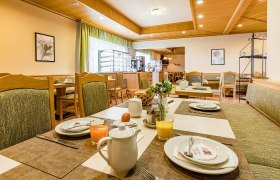 fruhstuck, © Hotel Garni Steinfeld Ein gemütlicher Frühstücksraum mit gedeckten Tischen, Saftgläsern und Kaffeekannen.