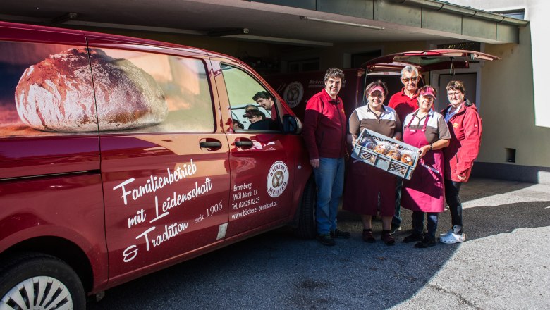 Gai drivers and suppliers, © Clemens Trenker, BA Five people hold a gray box of pastries next to a red van.