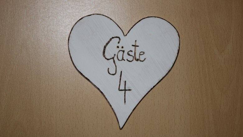 Eingangschild Gaeste 4, © Gruber Claudia Holzschild in Herzform mit der Aufschrift 'Gäste 4'.
