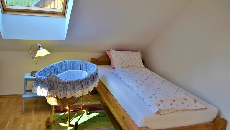 Bedroom, © Gluschitz-Goebel A cozy bedroom with single bed, baby cradle and skylight.
