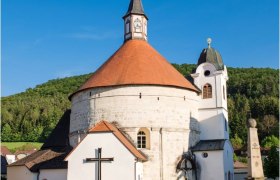 Pfarrkirche Scheiblingkirchen, © Walter Strobl, www.audivision.at Pfarrkirche Scheiblingkirchen mit rundem Turm und rotem Dach vor blauem Himmel.