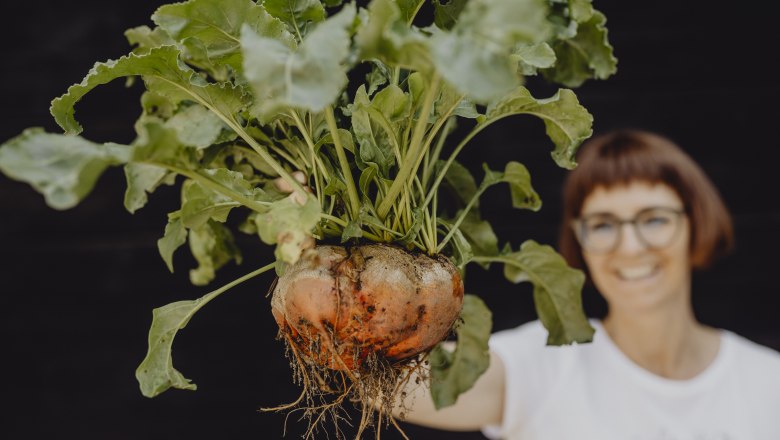 Vielfalt auch im eigener Kräuter-, Obst- und Gemüse-Garten, © Niederösterreich-Werbung/Sophie Menegaldo Frau hält große Rübe mit Blättern in der Hand.