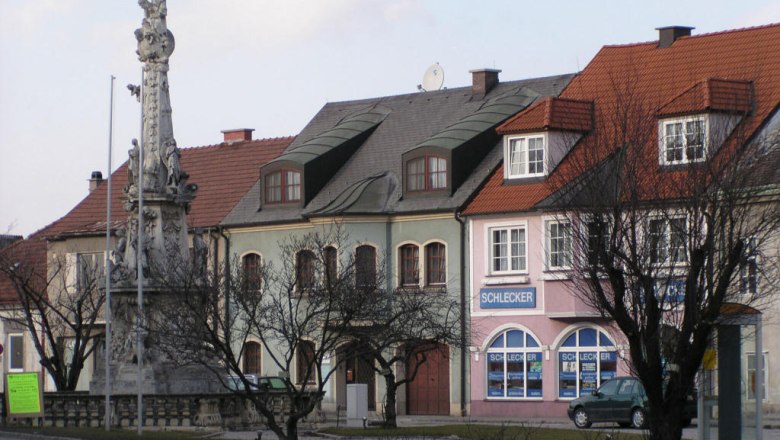 Ebenfurth, © Stadtgemeinde Ebenfurth Straßenszene in Ebenfurth mit historischen Gebäuden und einer Statue.