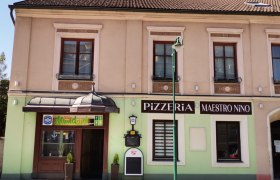 Pizzeria im Ortszentrum, © Wiener Alpen Fassade einer Pizzeria mit dem Namen Maestro Nino in einem zweistöckigen Gebäude.
