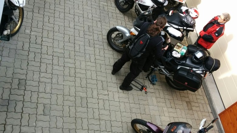 Platz vor dem Eingang, © Reep Mehrere Motorräder und Personen auf einem gepflasterten Platz vor einem Gebäude.