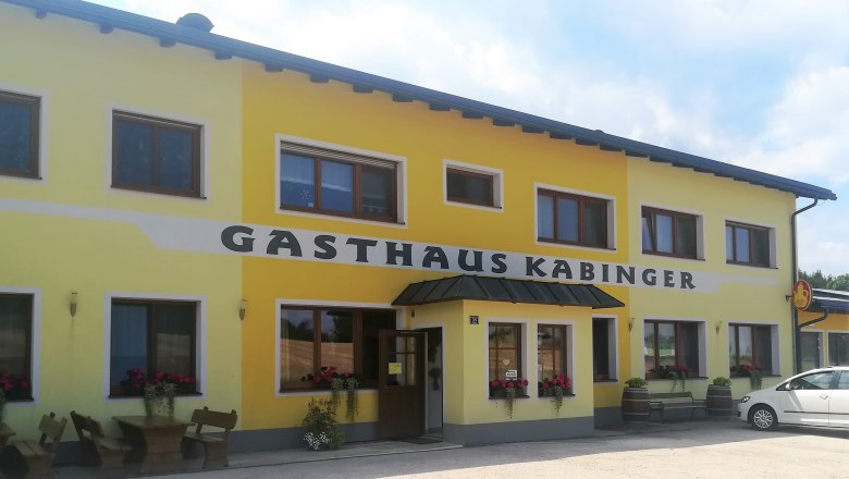 Gasthaus Kabinger in Bromberg, © Wiener Alpen Gelbes Gebäude mit der Aufschrift 'Gasthaus Kabinger'.