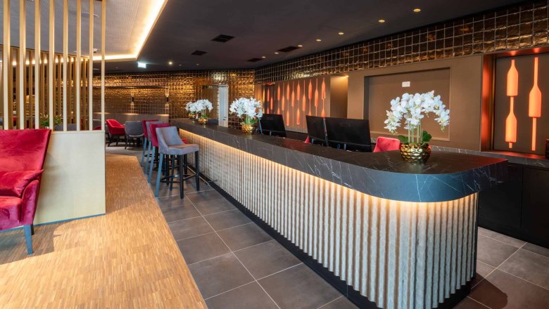 Reception, © Plaza Hotelgroup Modern hotel reception with stylish lighting and decoration.