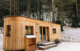 Wohnwagon Luna im Winter, © WW Wohnwagon GmbH Ein Wohnwagon aus Holz steht im verschneiten Wald.