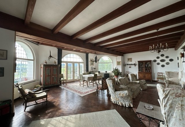 Schloss Gut Ziegersberg, © Schloss Gut Ziegersberg Ein elegantes Wohnzimmer mit antiken Möbeln, Holzbalkendecke, großen Fenstern und Teppichen.