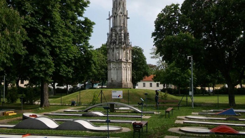 Golfanlage mit Spinnerin am Kreuz, © Familie Mauritz Minigolfplatz mit gotischem Denkmal im Hintergrund.