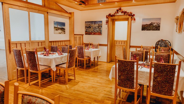 Gaststube und hauseigene Bühne, © Niederösterreich Werbung/Klaus Engelmayer Gemütliche Gaststube mit Holzmöbeln und dekorierten Tischen, umgeben von Bildern an den Wänden.