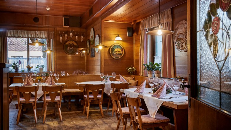 Hagyományos kocsma, © Niederösterreich Werbung/Andreas Hofer Hangulatos, faburkolatos kocsma, terített asztalokkal, székekkel és dekoratív elemekkel a falakon.