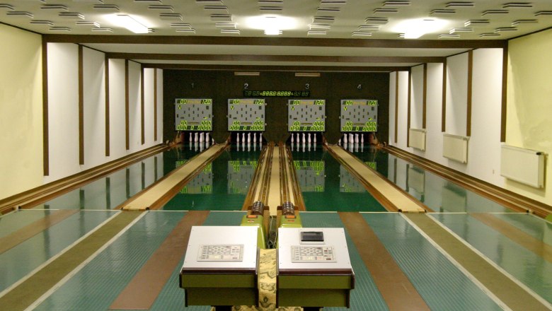 Bowling alley - Schneeweis, © Sabine Schneeweis Interior view of a bowling alley with four lanes and scoreboards.