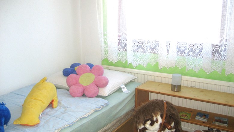 Bedroom 3, © Anke Spreitzer Children's room with bed, cuddly toys and toy horse.