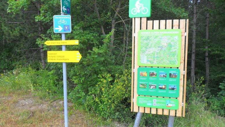 Radstartplatz-Tafel Bad Erlach, © ©Wiener Alpen Wegweiser und Informationstafel für Radfahrer in Bad Erlach, umgeben von Bäumen.