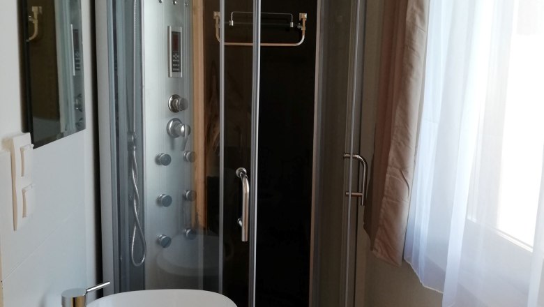 Apartment-bad, © Familie Weibels Modernes Badezimmer mit Duschkabine und Waschbecken.