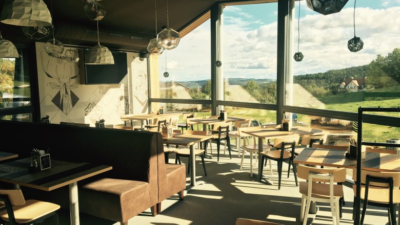 Rasten & Genießen mit Ausblick in der Wexl Lounge, © Familienarena Bucklige Welt-Wechselland GmbH Innenansicht der Wexl Lounge mit großen Fenstern und Blick auf die Landschaft.