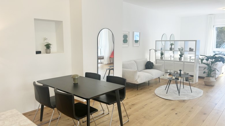 Studio, Die Feigenterrasse am Semmering, © Wiener Alpen Modernes Wohnzimmer mit Esstisch, Sofa und Regalen in einem offenen Raum.