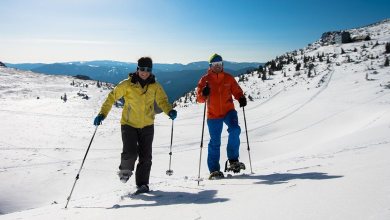 Berggasthof als Ausgangspunkt für Schneeschuh-Wanderungen, © Wiener Alpen - Ziegler Zwei Personen beim Schneeschuhwandern in einer verschneiten Berglandschaft.