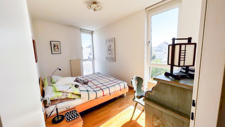 Room view, © Apartment am Stadtpark Bright bedroom with bed, desk and window.