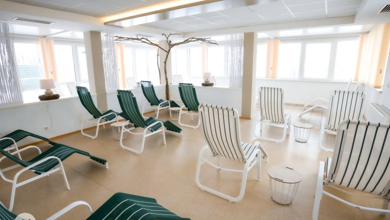 Ruhebereich, © TheVerve-Agentur (theverve.at) Ein heller Ruhebereich mit mehreren grünen Liegestühlen und kleinen Tischen.