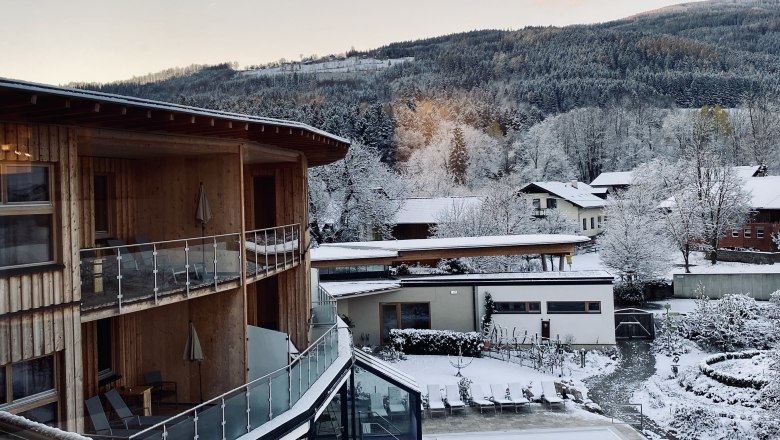 Morgenstimmung, © Peter Pichler Winterliche Landschaft mit schneebedeckten Gebäuden und Bäumen in den Bergen.