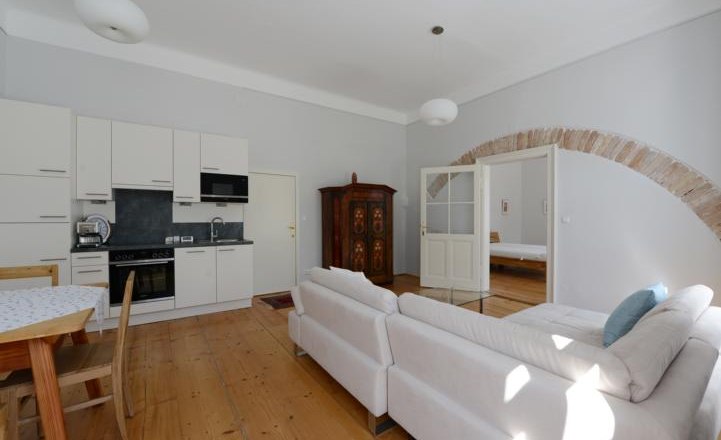 Apartment G2 in the Gerhardthof Reichenau, © Gerhardthof Reichenau Bright living room with kitchen, sofa and dining table.