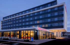 Hotelansicht, © Hilton Garden Inn Wiener Neustadt Außenansicht eines modernen Hotels bei Dämmerung.