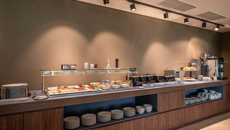 Das Frühstücksbuffet, © Philipp Blickfang Ein Frühstücksbuffet mit verschiedenen Speisen und Geschirr in einem modernen Raum.
