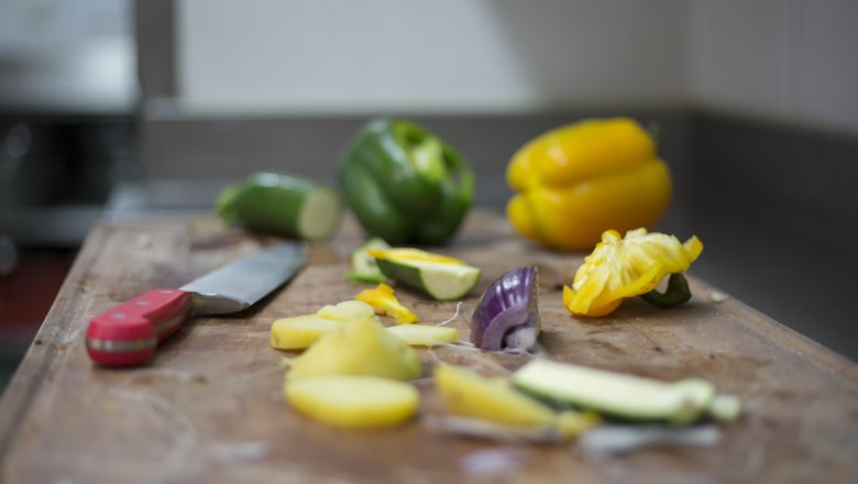 Alpen-Aktiv-Landgasthof zur Schubertlinde, © Patrick Haberler Gemüse und Messer auf einem Schneidebrett in einer Küche.