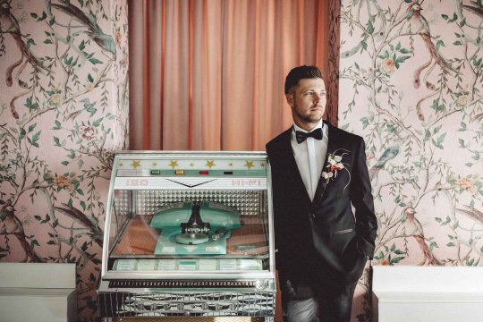 Hochzeit mit Extravaganz im Fernblick, © ivoryrose Bräutigam steht neben einer Jukebox