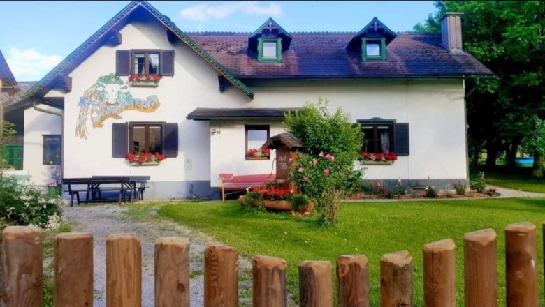 Leo_Hof, © Leo-Hof/Sandra Reinisch Ein traditionelles Haus mit Blumen an den Fenstern und einem Holzzaun im Vordergrund.