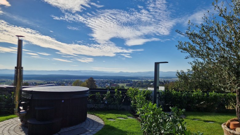 Hot Tub Johannesbachklamm Chalet, © Johannesbachklamm Chalet Ein runder Whirlpool im Garten mit Blick auf eine weite Landschaft und blauen Himmel.