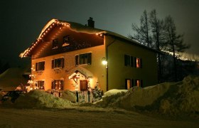 Haus Kohl im Winter, © Tourismusbüro Semmering Ein beleuchtetes Haus im Schnee bei Nacht, umgeben von hohen Schneehaufen.
