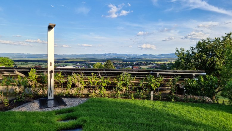 Solar Dusche Johannesbachklamm Chalet, © Johannesbachklamm Chalet Solar-Dusche im Garten mit Blick auf Landschaft und blauen Himmel.
