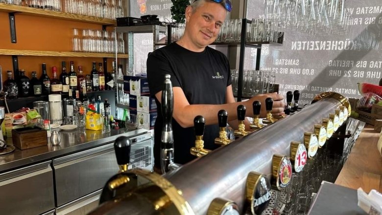 Siegl's Pub, © Siegl's Pub Ein Barkeeper zapft Bier an einer Theke mit mehreren Zapfhähnen in einer Bar.