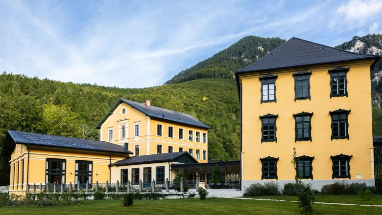 Thalhof Außenansicht, © Thalhof, Katrin Nusterer Außenansicht des gelben Thalhofs vor bewaldeten Bergen.